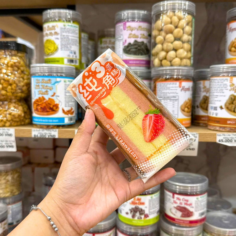 Mặt trước gói bánh với hình dâu và tông hồng vàng đặc trưng