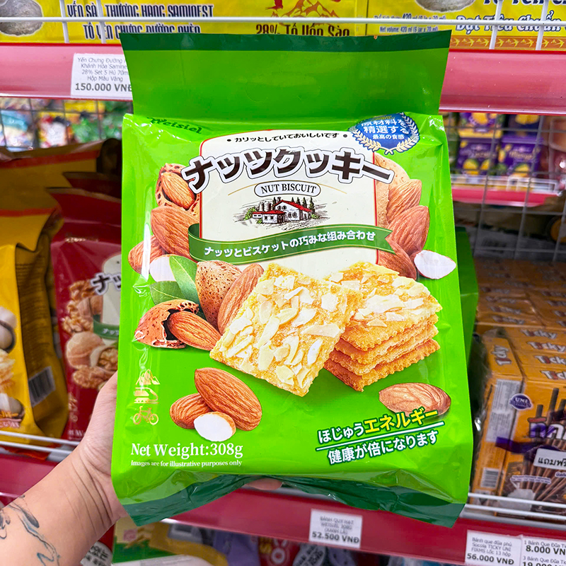 Mặt trước bao bì màu xanh lá với hình bánh phủ lát hạnh nhân