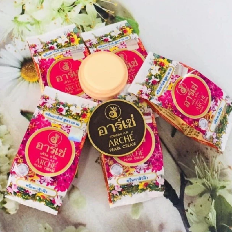Các hộp Arche Pearl Cream AC tông hồng nổi bật bên cạnh hũ kem tròn nhỏ