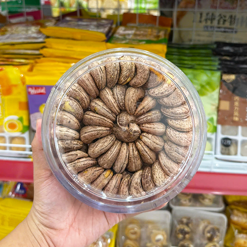 Hạt điều nguyên vỏ xếp kín trong hộp nhựa tròn trong suốt