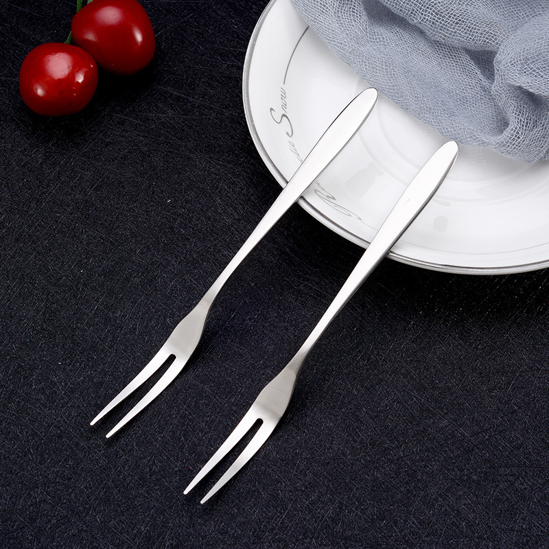 Hai chiếc nĩa xiên inox trên nền tối