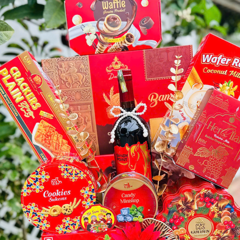 Các hộp bánh kẹo và chai trung tâm được sắp xếp đầy đặn, nổi bật