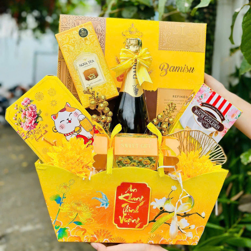 Phiên bản tông vàng với hộp bánh, trà, kẹo và chai đồ uống được sắp xếp gọn mắt