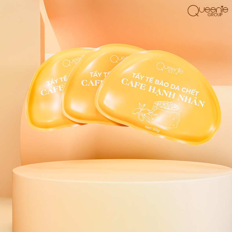 Ba gói tẩy tế bào chết cafe hạnh nhân 50g trên nền cam nhạt