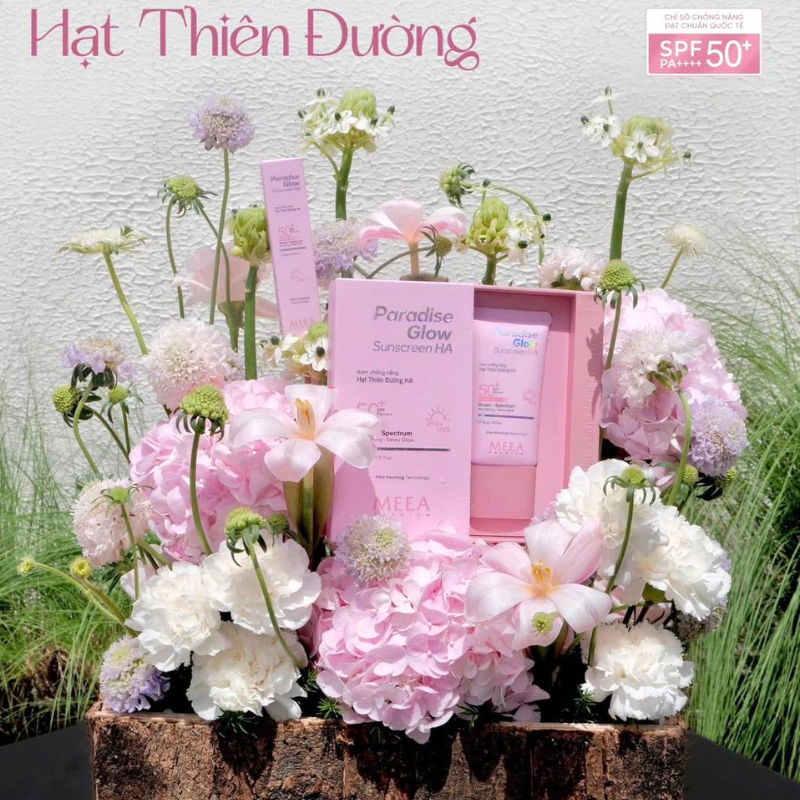 Hộp hồng đặt giữa cụm hoa, nổi bật chữ “Hạt Thiên Đường”.
