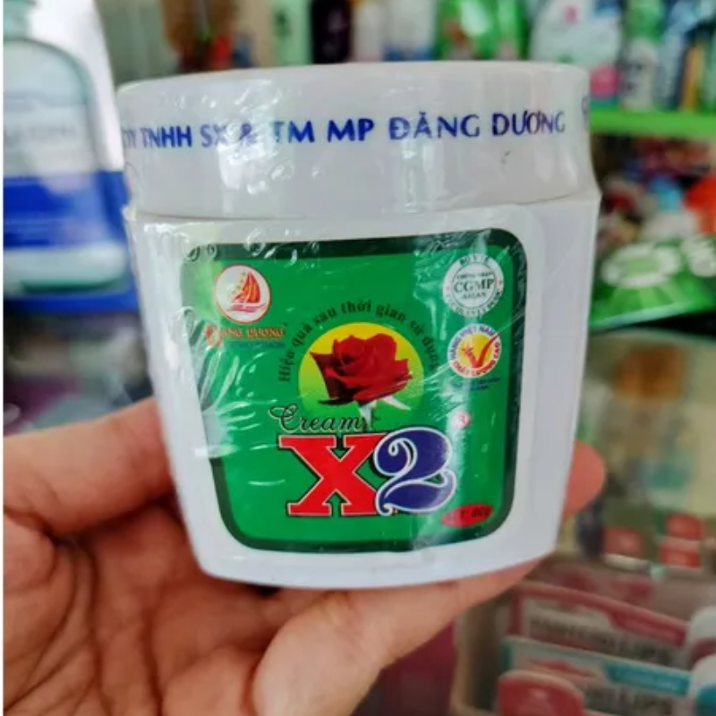 Sản phẩm được cầm trên tay, thấy rõ nắp trắng và nhãn trước.