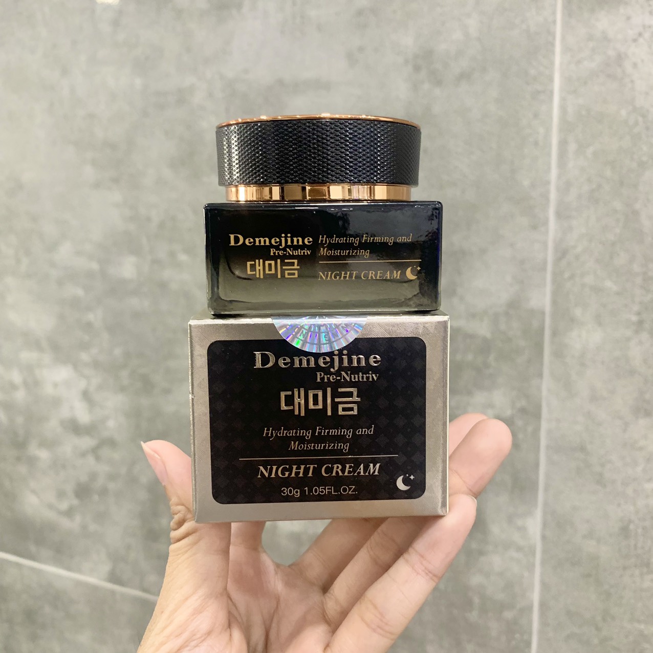 Bộ sản phẩm gồm hộp và hũ kem cầm trên tay