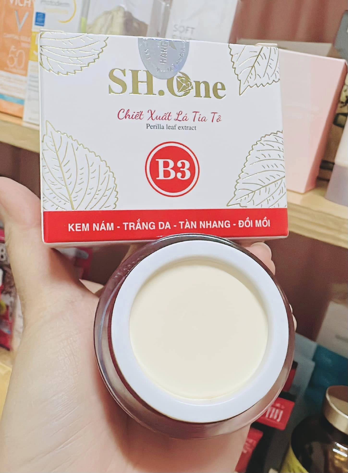 Cận cảnh hộp kem và chất kem màu sáng bên trong hũ