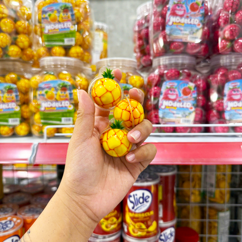 Các viên kẹo tạo hình trái dứa cầm trên tay