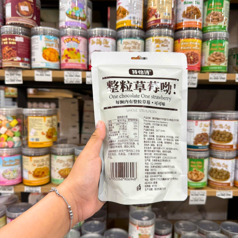 Mặt trước túi kẹo màu đỏ với hình viên kẹo và phần dâu tây bên trong