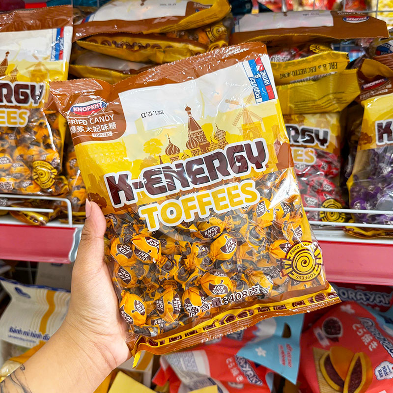 Mặt trước bịch vàng K‑Energy Toffees, kẹo gói rời bên trong