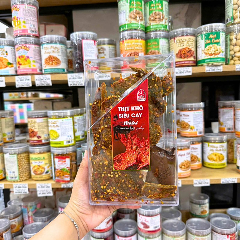 Mặt trước hộp nhựa trong suốt với nhãn Thịt Khô Siêu Cay Malai