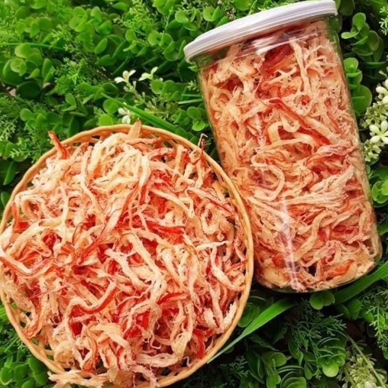 Sợi mực xé khô trong hộp, màu sắc và kết cấu nhìn rõ.