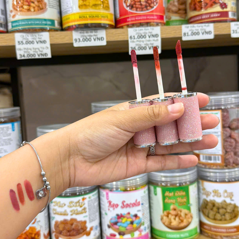 Ba đầu cọ mở sẵn với vệt màu thử trên tay để so sánh sắc độ.