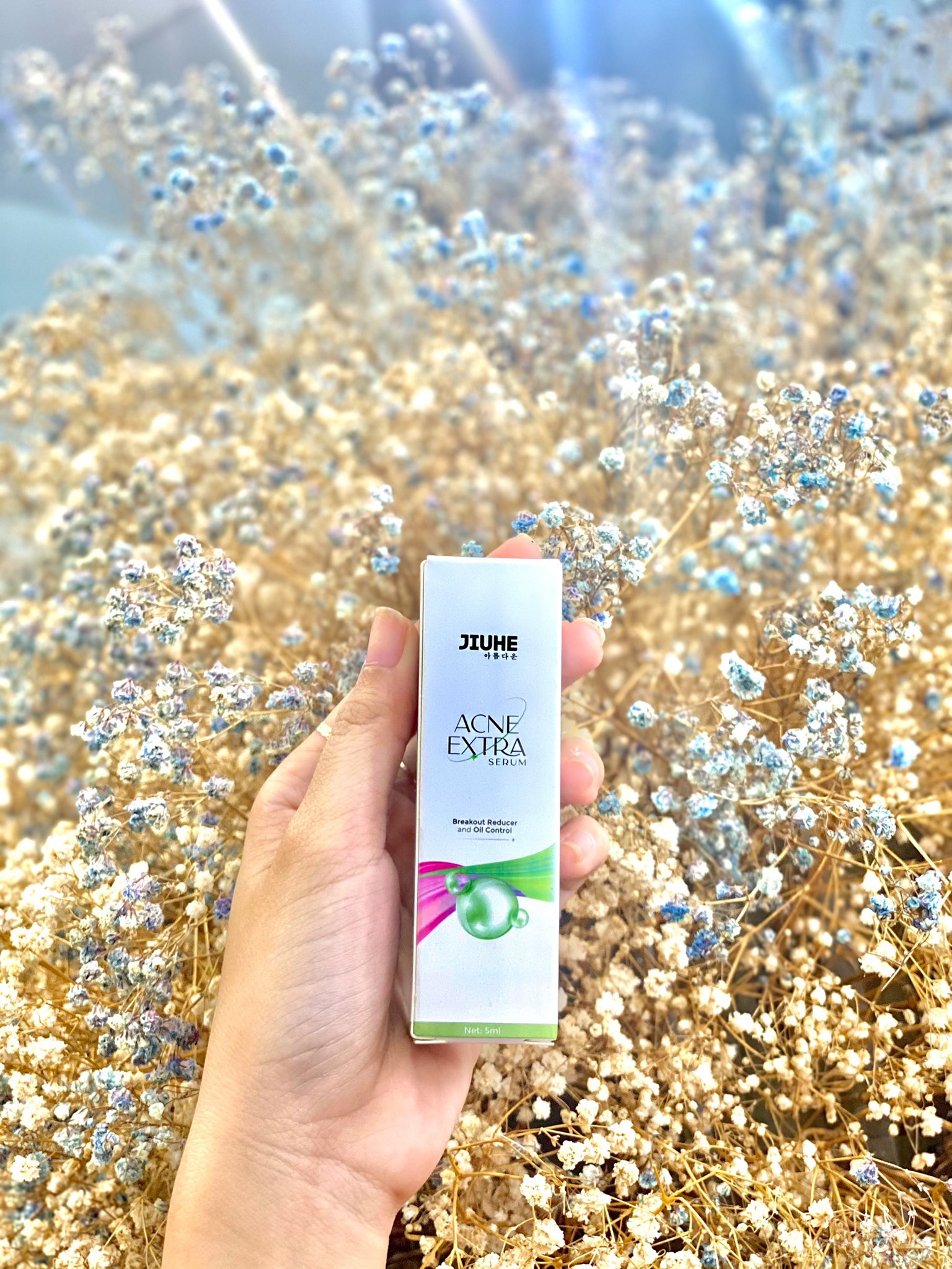Hộp sản phẩm cầm tay với thiết kế Acne Extra Serum 5ml