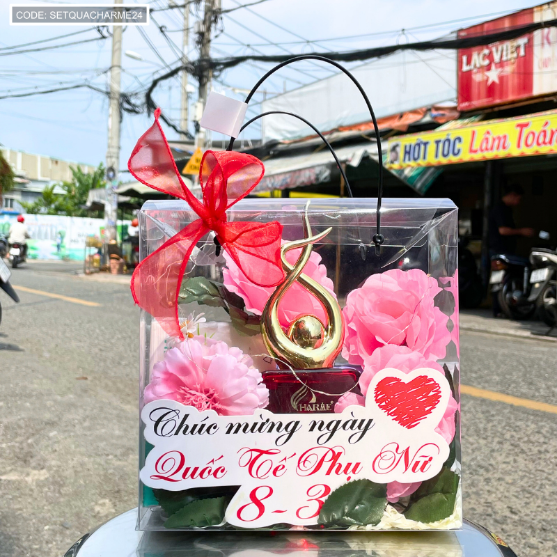Mặt trước set quà với bảng chúc mừng, hoa trang trí và nơ đỏ