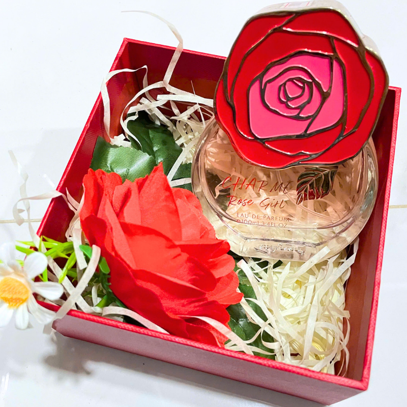Bố cục set quà với chai nước hoa, hoa trang trí và hộp cứng