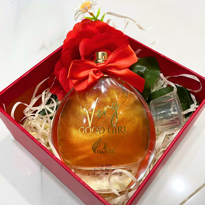 Cận cảnh set quà với chai nước hoa, hoa trang trí và giấy rơm