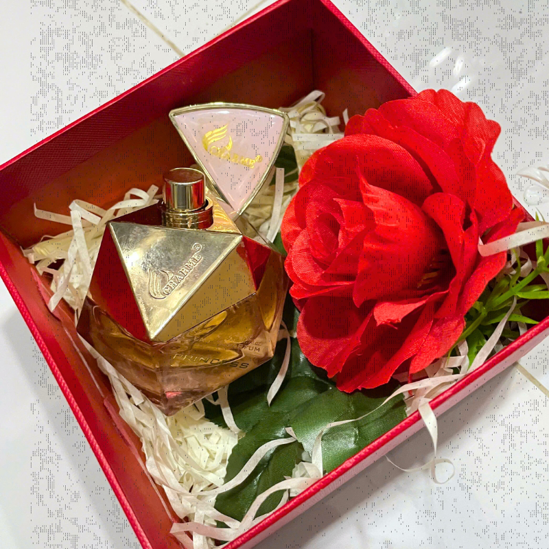 Bộ quà gồm chai nước hoa, hoa trang trí và giấy rơm lót hộp