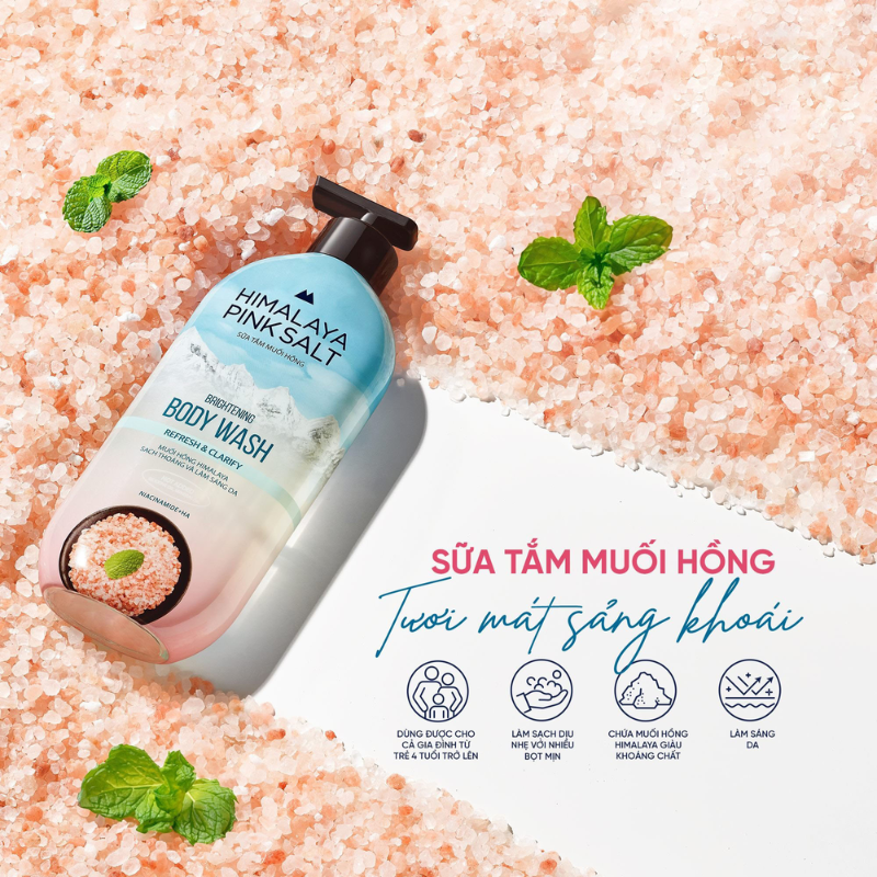 Chai pump đặt trên nền muối hồng, điểm lá bạc hà xanh mát.