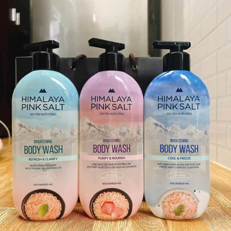 Ba chai Himalaya Pink Salt đặt trên kệ gỗ trong không gian phòng tắm.