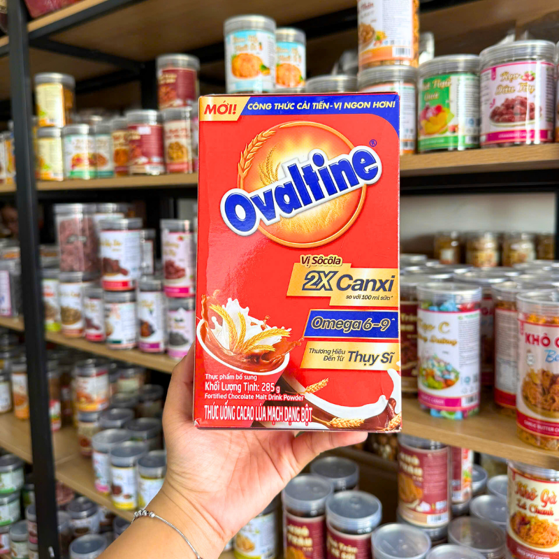 Mặt trước hộp Ovaltine vị socola 285g với thông tin 2X canxi và Omega 6-9