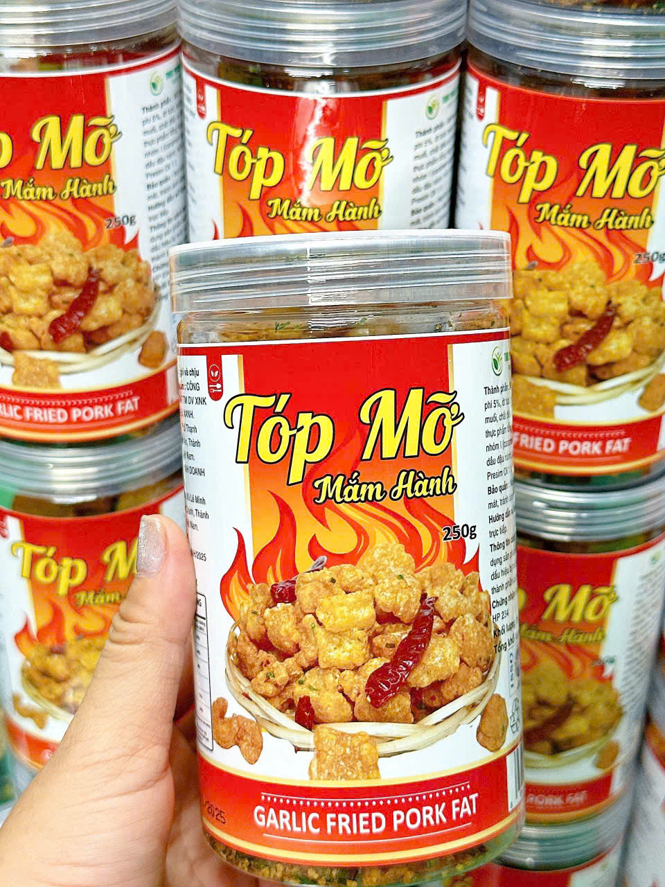 Hũ tóp mỡ mắm hành cầm trên tay, dễ hình dung kích cỡ hộp PET